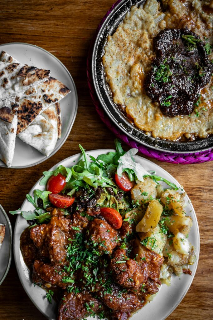 Pour une image de feijoada : "Plat traditionnel brésilien de feijoada, composé de haricots noirs, de viande de porc, servi avec du riz et du chou."